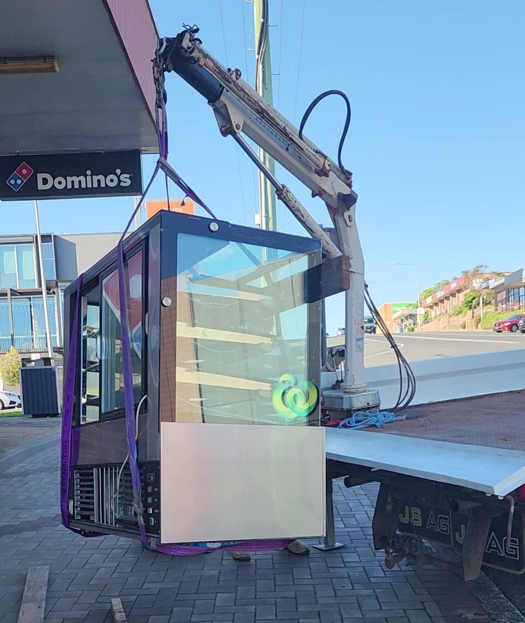 Crane truck lifting a glass cake display cabinet